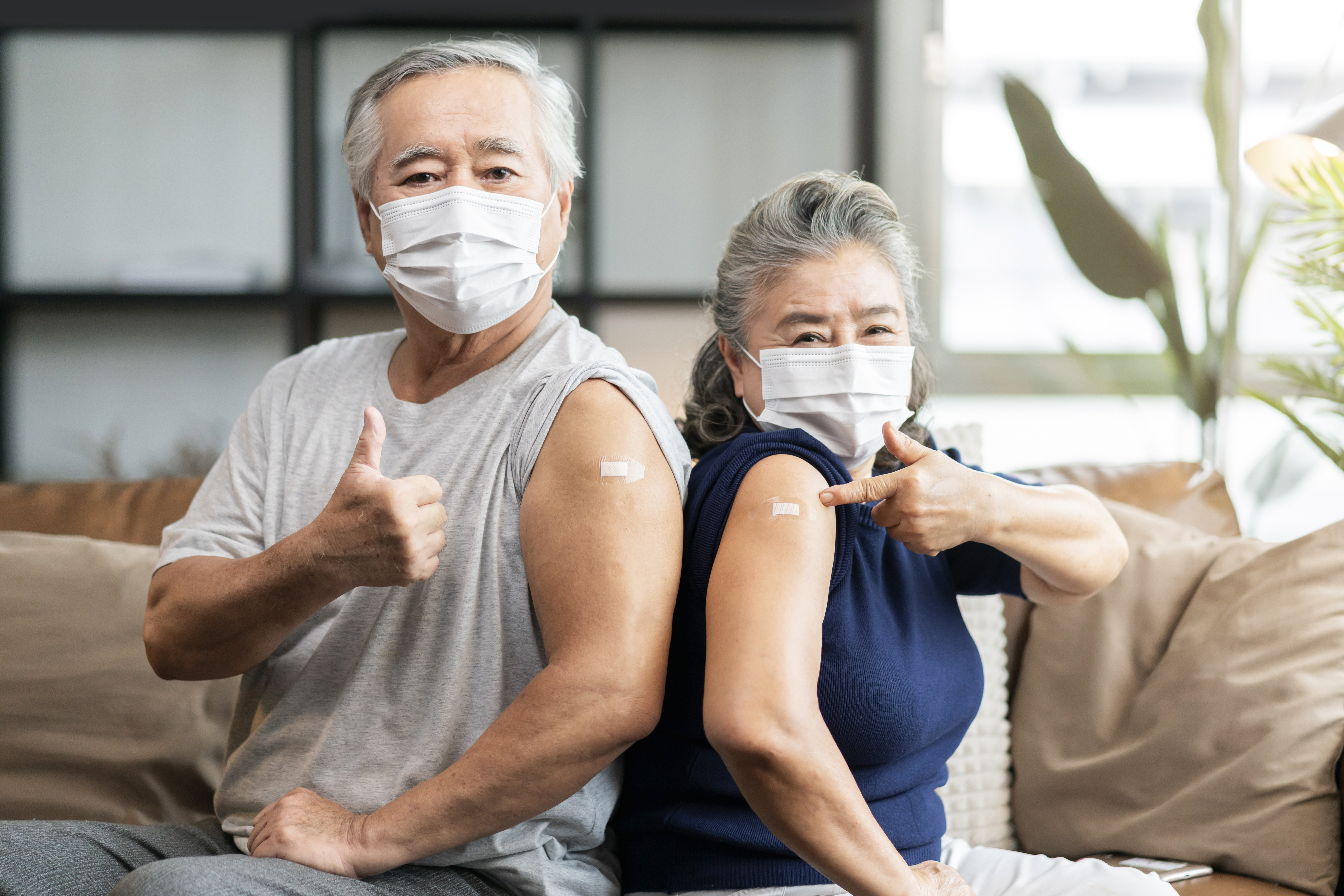 old-asian-senior-couple-wearing-face-mask-virus-protection-happiness-cheerful-show-bandage-injection-covid19-vaccinated-with-hand-gesture-point-confident-virus-protection